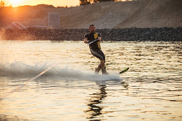 istock Man wakeboarding on lake at sunset 638567824