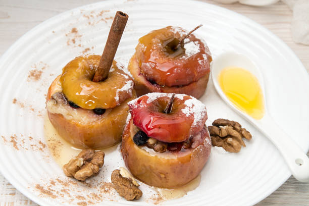 istock Baked apples stuffed with walnuts and honey on white plate 638568448