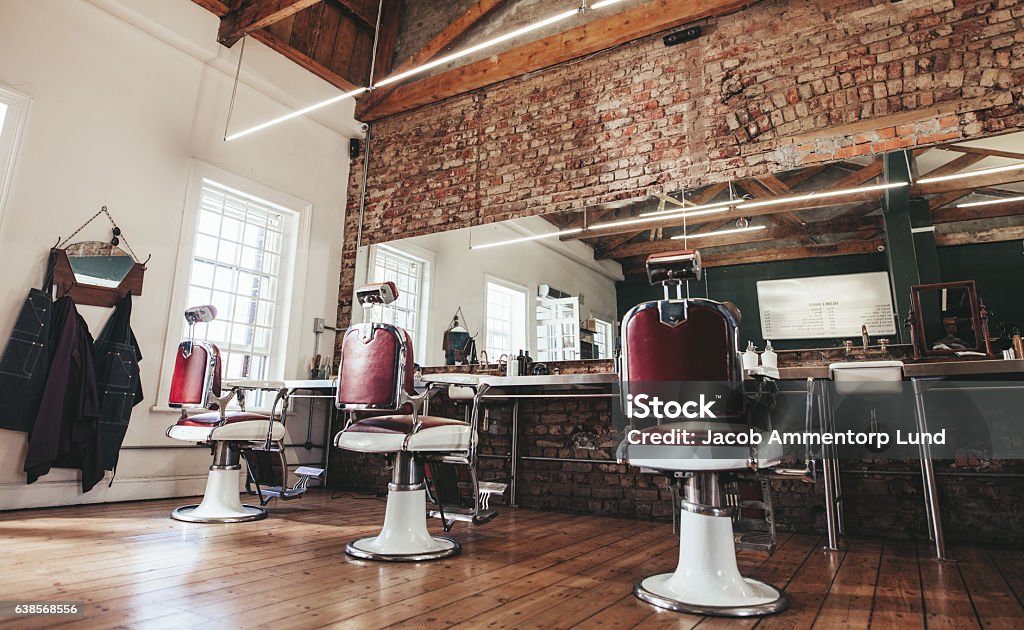 Retro styled barbershop. Horizontal shot of empty chairs in retro styled barbershop. Hair salon interior. Barber Shop Stock Photo