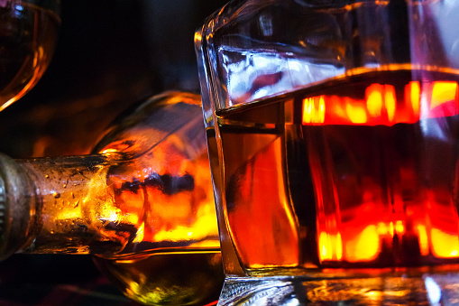 Alcoholic drink background with open fire . Whisky, whiskey, brandy, cognac liqueur