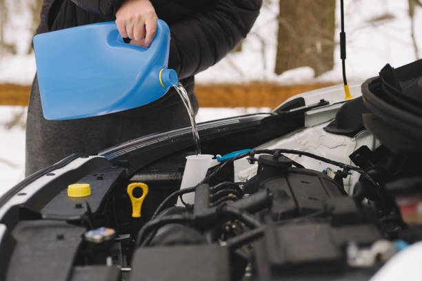 istock Man pouring car winter windshield washer fluid 638570878