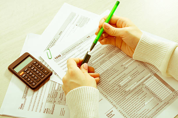 istock Female hands and tax form 638572582