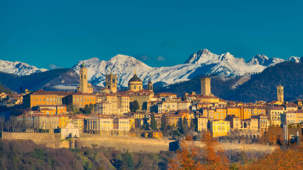 The city of Bergamo with high The city of Bergamo with high behind the White Mountains of snow the early morning sun bell tower tower photos stock pictures, royalty-free photos & images