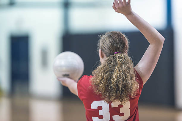 pallavolista al liceo femminile in servizio durante una partita - sport volleyball high school student teenager foto e immagini stock