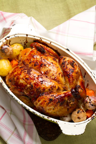 istock Baked whole chicken with garlic, potatoes and carrots 638576796