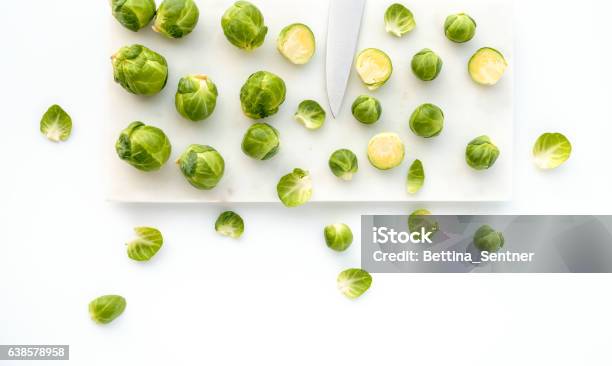 Brussels Sprouts And Knife On White Marble Stock Photo - Download Image Now - Brussels Sprout, Directly Above, Leaf