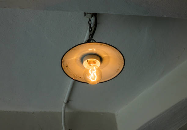 istock Lighting light bulb on the cable in dark room 638579424