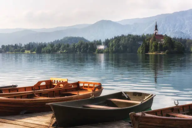 Photo of Wooden pier with pleasure boats on the water, lake Bled