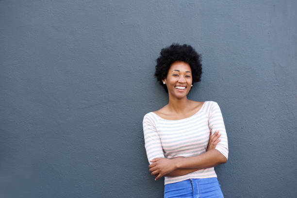 istock Smiling african woman standing against gray wall 638583156