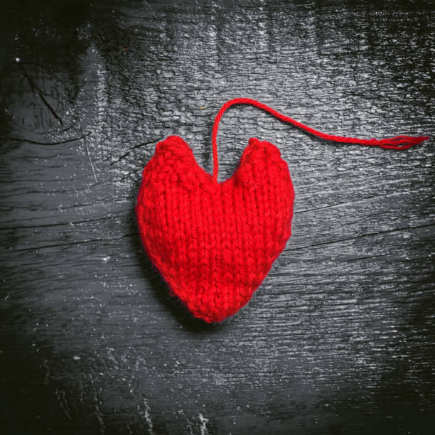 istock Colorful knitted hearts on the dark boards 638591294