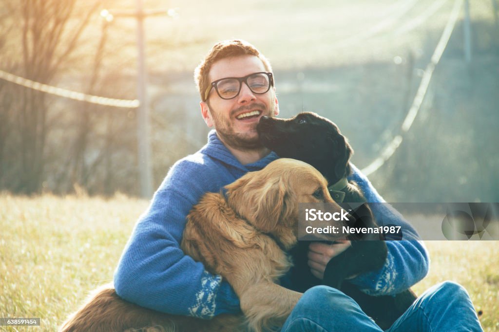 young man having a fun with dogs in the nature Dog Stock Photo