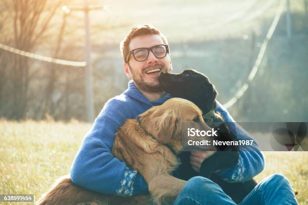 Young Man Having A Fun With Dogs In The Nature Stock Photo - Download Image Now - Dog, Men, Pets