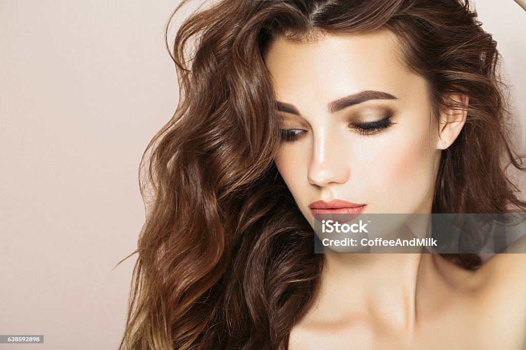 Beautiful woman Studio shot of young beautiful woman on light background. Professional make-up and hair style. Beauty Stock Photo