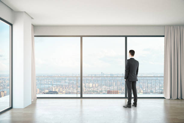 istock Man in room with city view 638593368