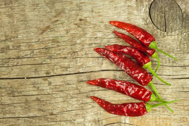 istock Dried chili peppers on old wooden background. 638593932
