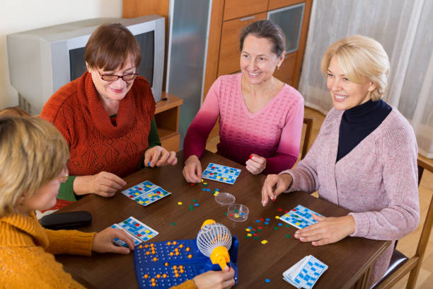 Pensioners playing board game Several happy female pensioners playing board game in the room at home dibs stock pictures, royalty-free photos & images