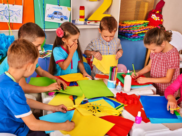 istock Child cutting paper in class. Development social lerning in school. 638594950