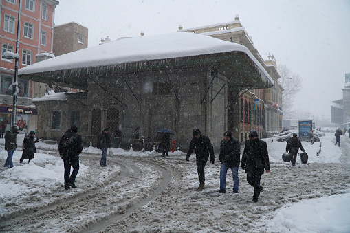 Istanbul, Eminonu, Turkey - January 9, 2017: Istanbul was covered with snow. This blizzard was the strongest of the last 30 years. There were people at the streets of The Eminonu with a fountain.