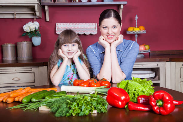 istock Mother and daughter having fun and making vegetable salad together. 638596476