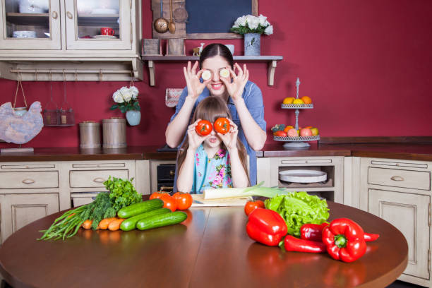 istock Mother and daughter having fun and making vegetable salad together. 638596794