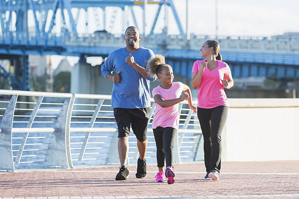 famille noire restant en forme, puissance marchant sur le front de mer - staying fit photos et images de collection