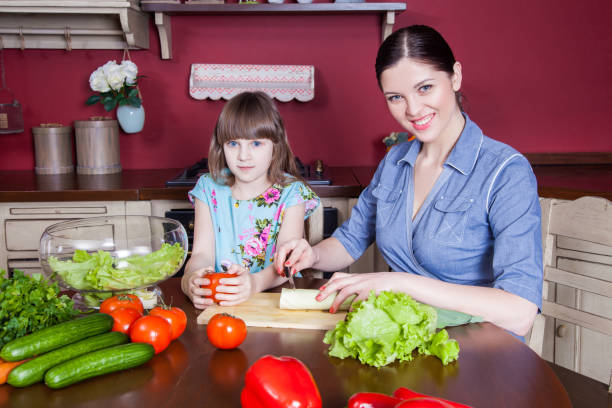 istock Mother and daughter having fun and making vegetable salad together. 638597032