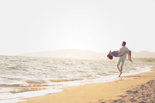 istock happy couple running on the beach 638598576