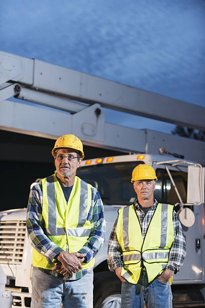 istock Two workmen in safety vests with truck 638599130