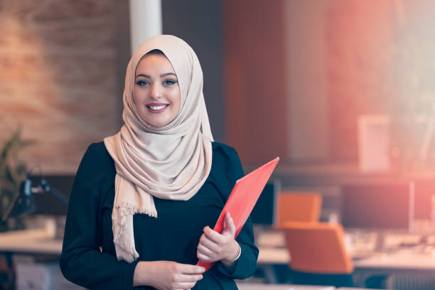 arabian negócios mulher segurando a pasta na inicialização de escritório moderna - red veil - fotografias e filmes do acervo