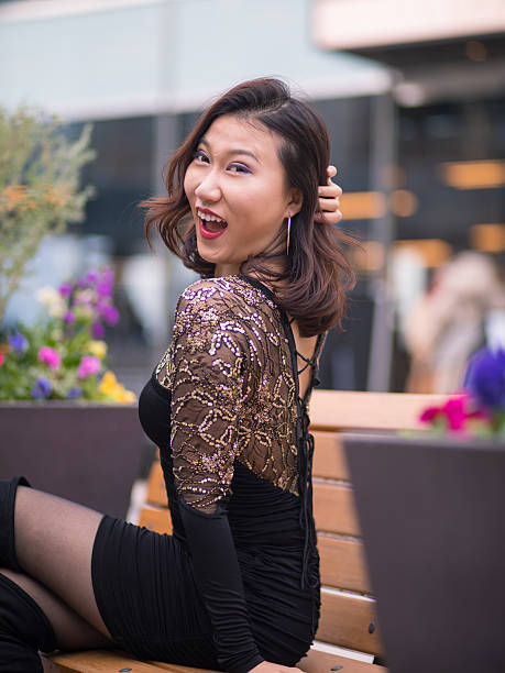 istock Young woman lookin over shoulder, sitting on bench 638601570
