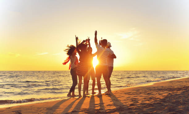 group of young people dancing at the beach - evening sunlight imagens e fotografias de stock