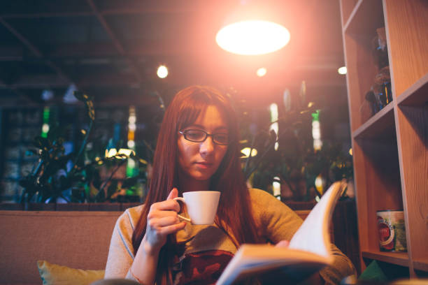 istock female is holding open book. Woman  reading a  with coffee 638602030