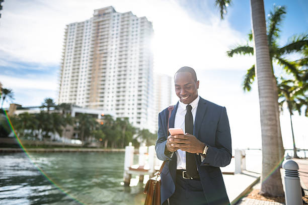 hombre de negocios enviando mensajes de texto en miami - travel people traveling business travel vacations fotografías e imágenes de stock