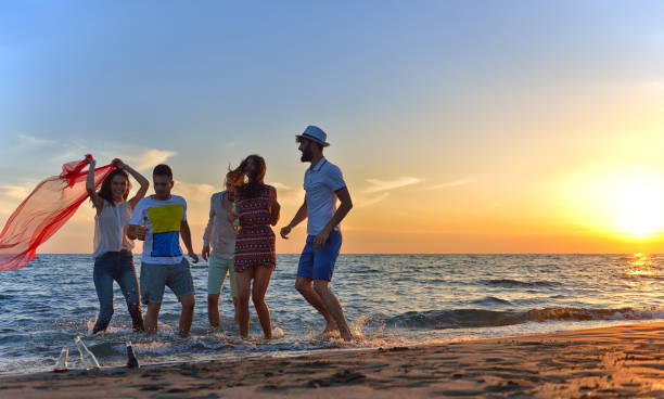 istock group of young people dancing at the beach 638603442
