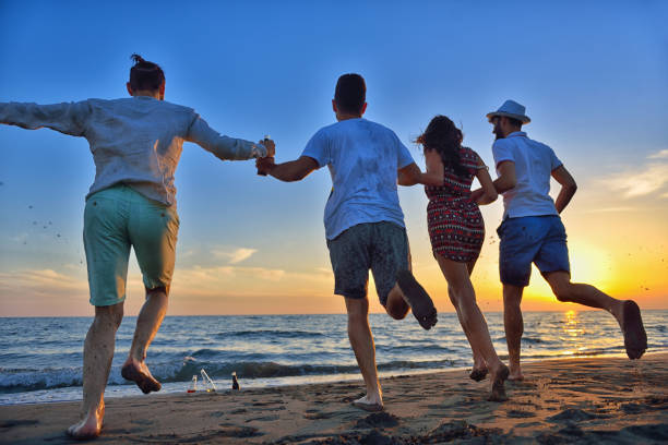 istock group of young people dancing at the beach 638603540