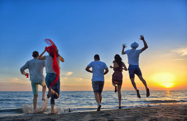 istock group of young people dancing at the beach 638603586