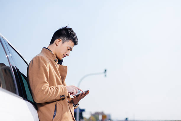 istock young asian man with tablet on road 638604126
