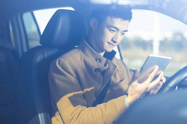 istock young asian man  hold tablet in car 638604172