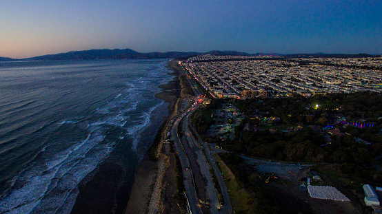 Aerial view of coastline and city edge at sunset