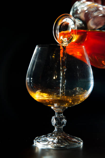 istock Cognac is poured from a bottle into  glass 638610472