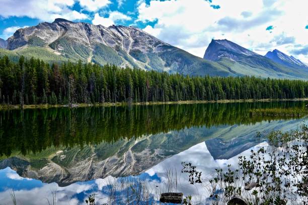 istock Crystal clear water in alpine lake, mountains, clouds and reflections. 638610932