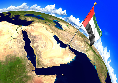 3D render of the national flag of United Arab Emirates over the geographic location of the country on a world map. Parts of this image furnished by NASA.