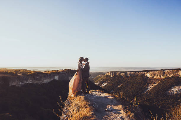 istock Bride and groom walking in mountains at sunset 638620354