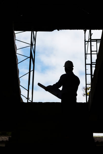 istock Silhouette of Engineer Architect working at Construction Site with blueprint 638623170