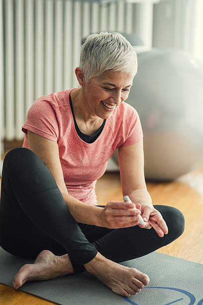 Femme mature faisant un test de glycémie après l’exercice. - Photo