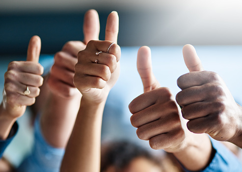 Shot of a group of creative businesspeople giving thumbs up while standing in their office