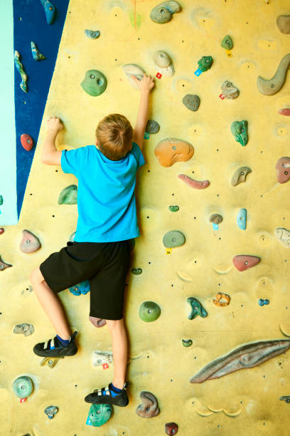 istock Free climber child young boy practicing on artificial boulders 638624058