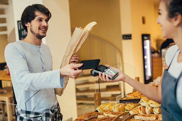istock Young man making a contactless payment at a bakery 638624218