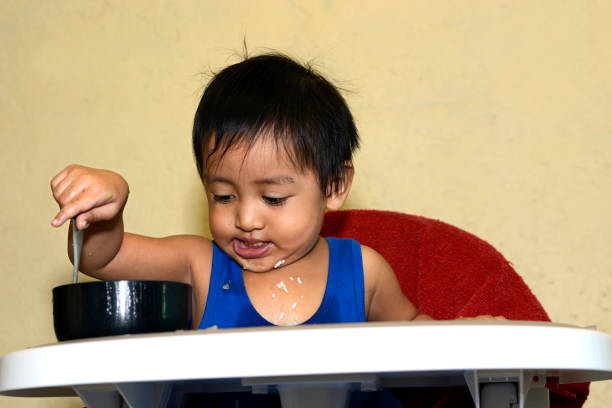 istock One 1 year old baby boy spoon rice from bowl 638628496