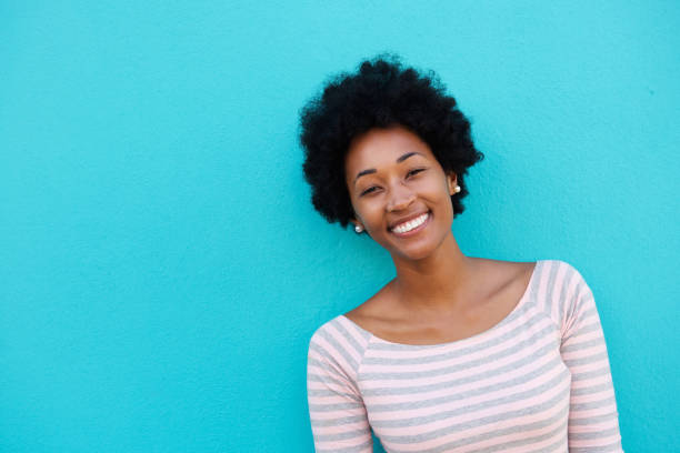 istock Cheerful woman standing against blue wall 638628958
